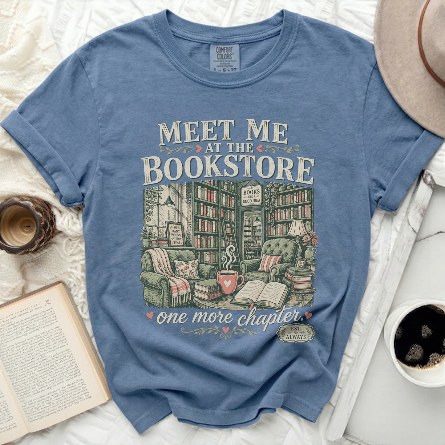 Blue t-shirt with "Meet Me at the Bookstore" and book illustrations.