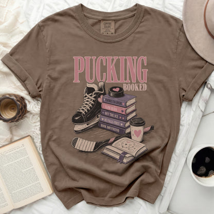 Brown t-shirt with "Pucking Booked" and book-themed sayings.