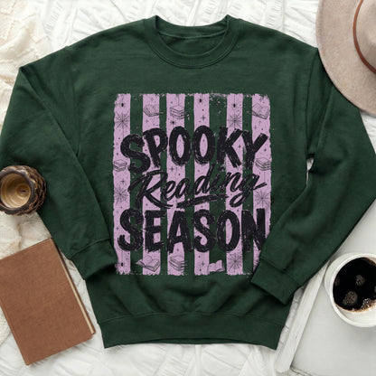 Dark green sweatshirt with "Spooky Reading Season" text and Halloween-themed graphics.