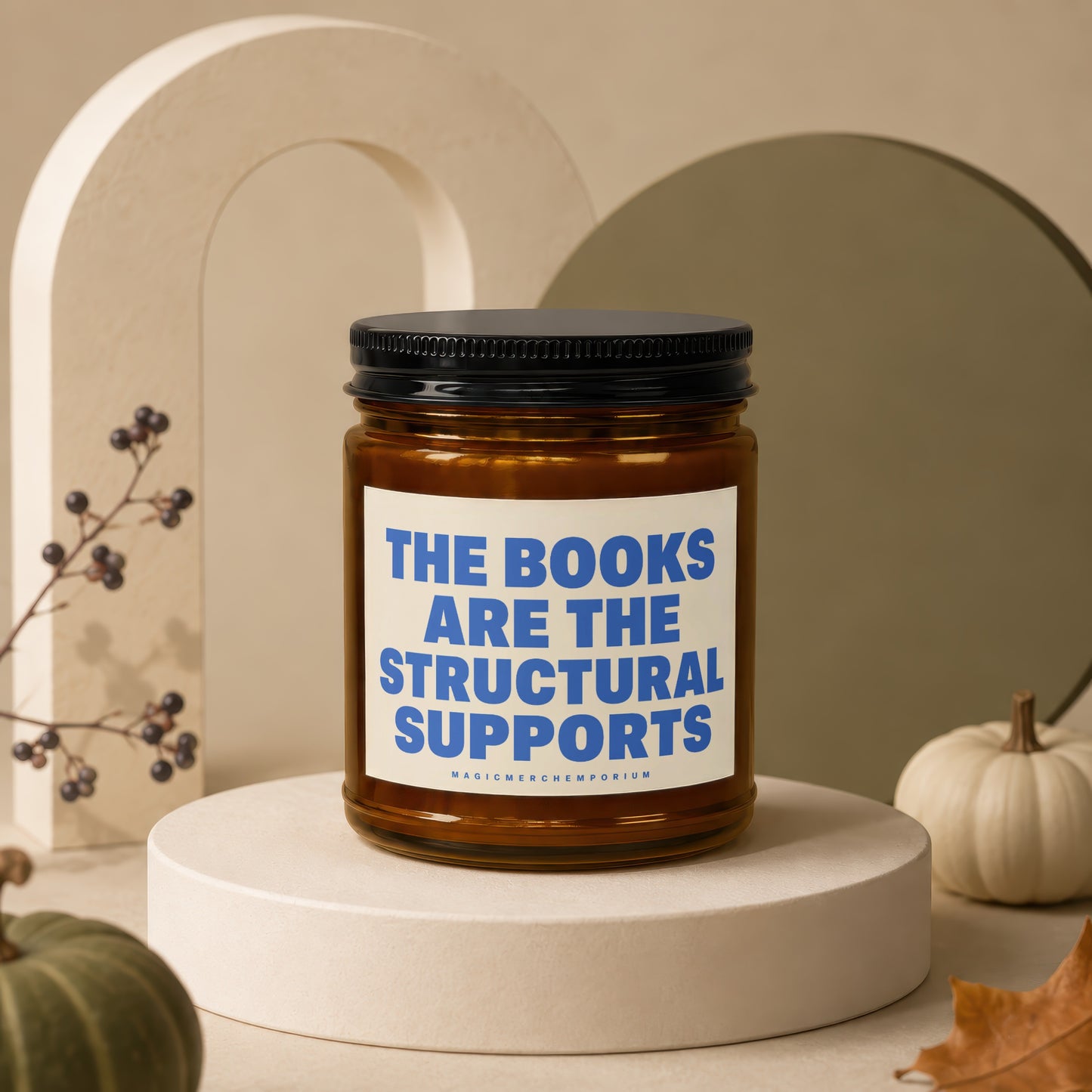 Amber jar candle with black lid featuring text: "The books are the structural supports".