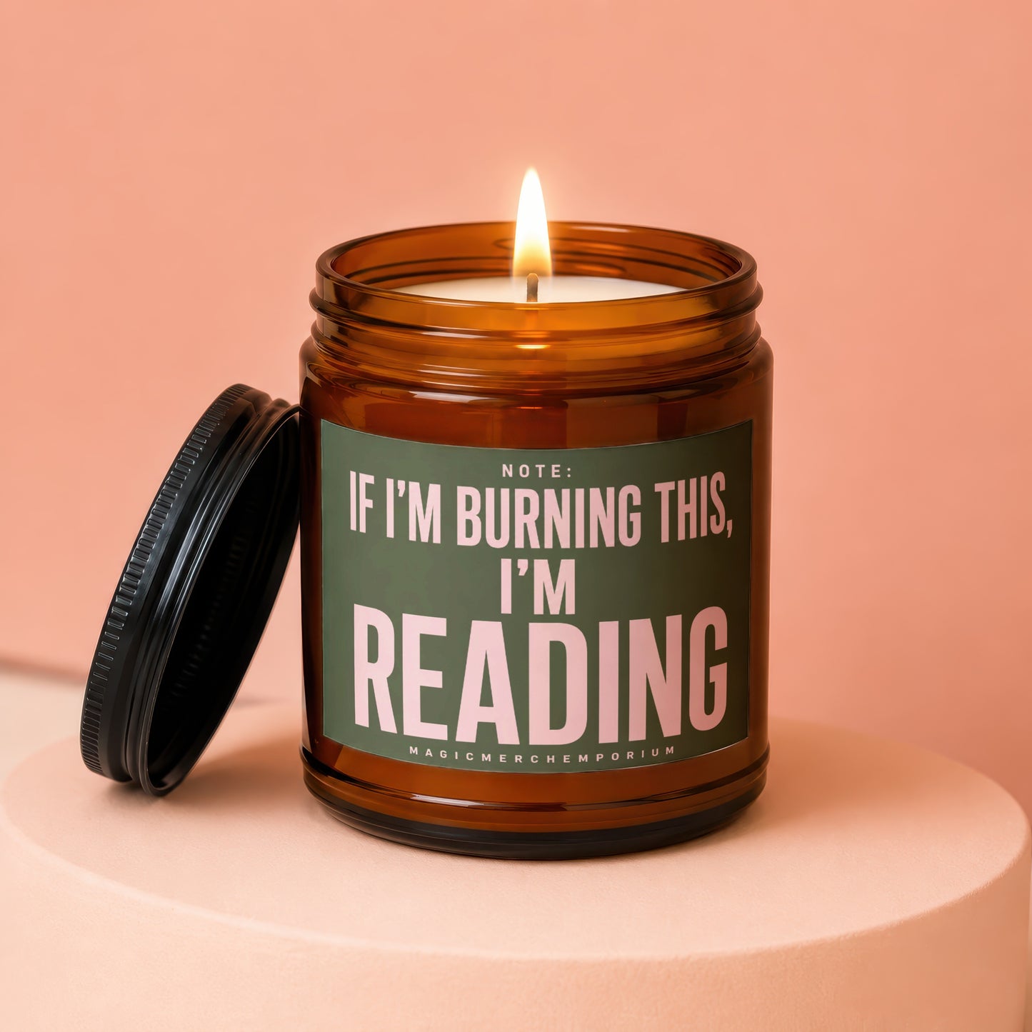 Amber jar candle with lit wick, lid removed, reads "If I'm Burning This, I'm Reading."