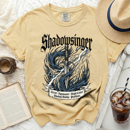 Yellow t-shirt with "Shadowsinger" and sword graphic.