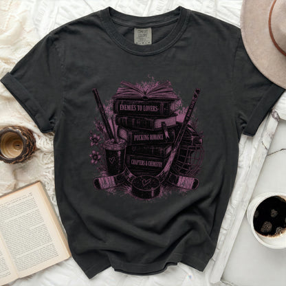 Graphic tee with stack of books, hockey stick, and puck graphic.