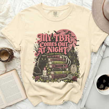 Cream t-shirt with "My TBR Comes Out At Night" graphic featuring a black cat and books.