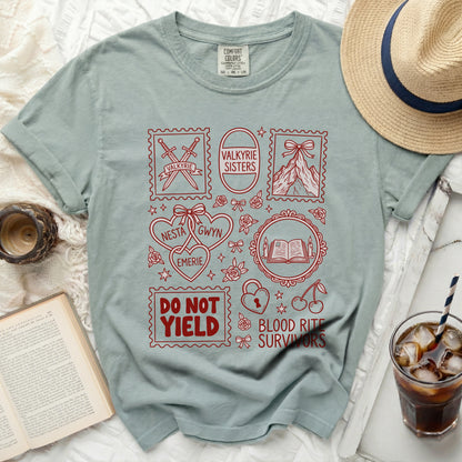 Light blue t-shirt with red graphic of stamps, names, and phrases.