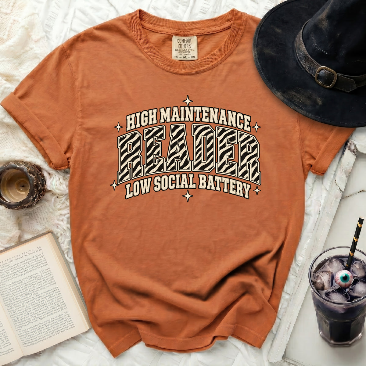Orange t-shirt with "HIGH MAINTENANCE READER LOW SOCIAL BATTERY" graphic.