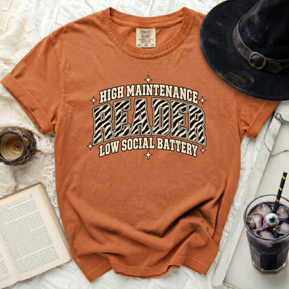 Orange t-shirt with "HIGH MAINTENANCE READER LOW SOCIAL BATTERY" graphic.