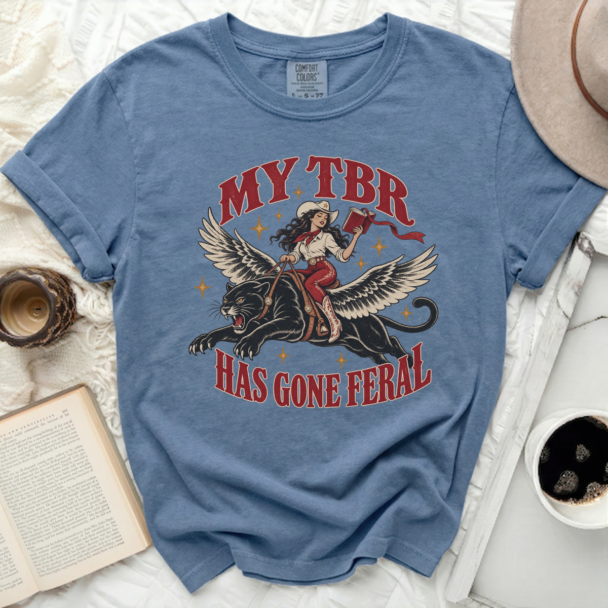 T-shirt with distressed graphic of winged panther ridden by cowgirl, "MY TBR HAS GONE FERAL".