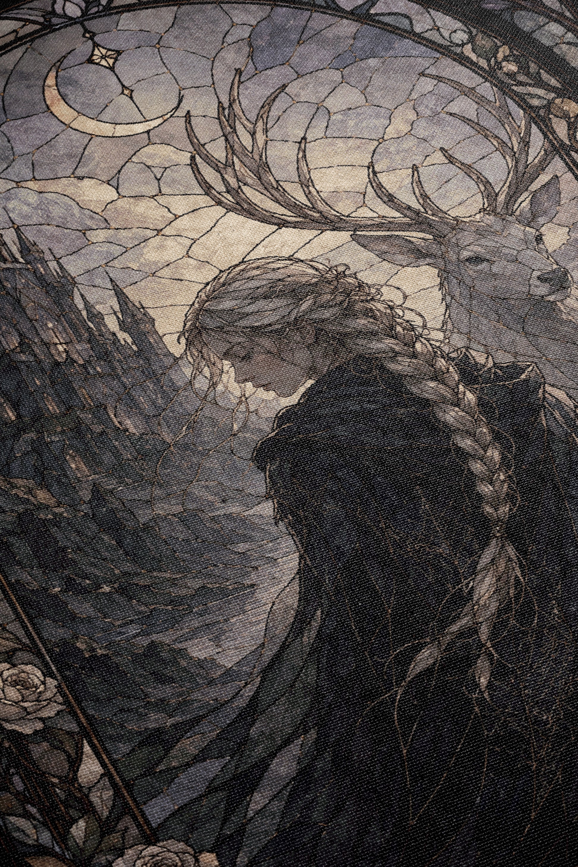 The image is a detailed illustration featuring a woman with braided hair, wearing a dark outfit, standing in front of a deer with antlers. The background depicts a landscape with mountains and a crescent moon.