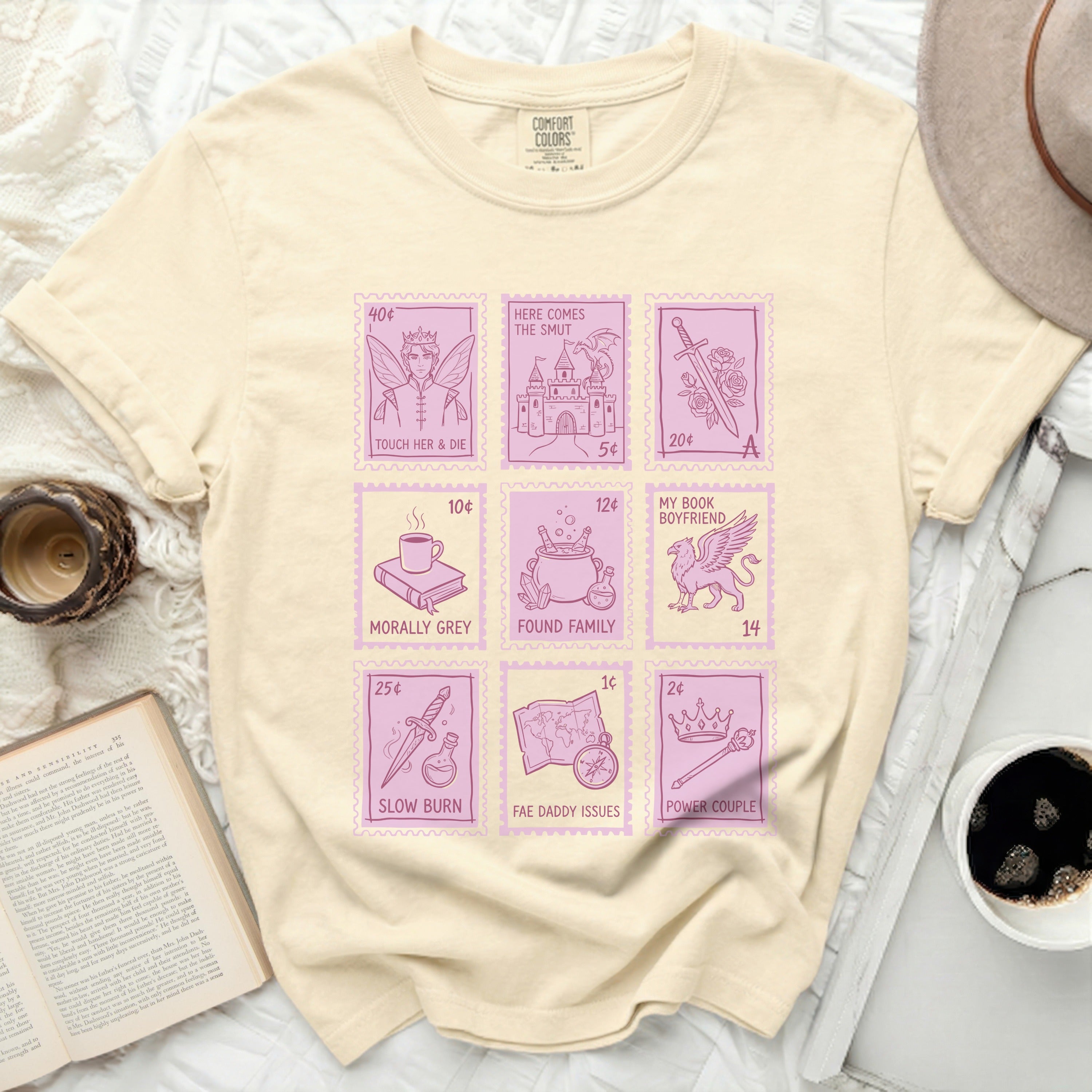 Light yellow t-shirt with pink stamp graphics of book titles.