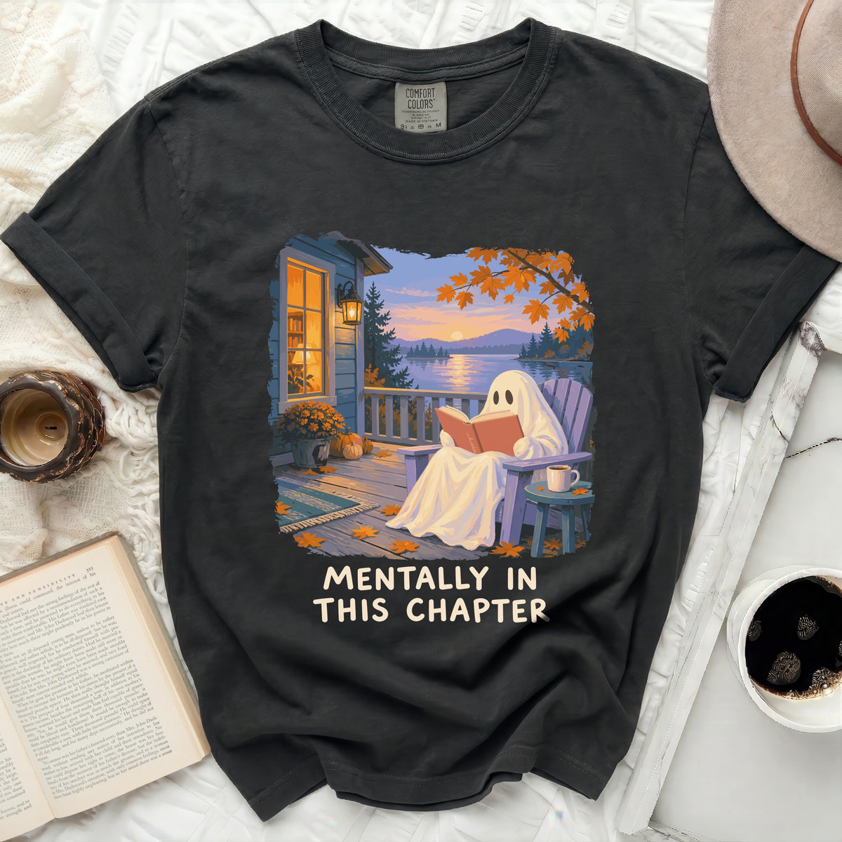 Black t-shirt with a graphic of a ghost reading a book by a lake, "MENTALLY IN THIS CHAPTER".