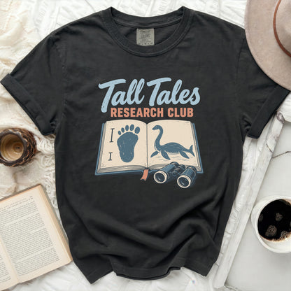 Dark gray t-shirt with "Tall Tales Research Club" text and book graphic.
