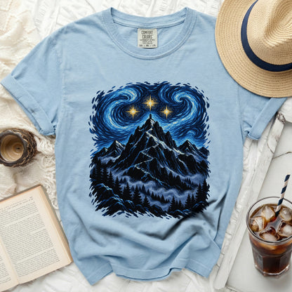 Light blue t-shirt with a mountain landscape under a starry, swirling sky.
