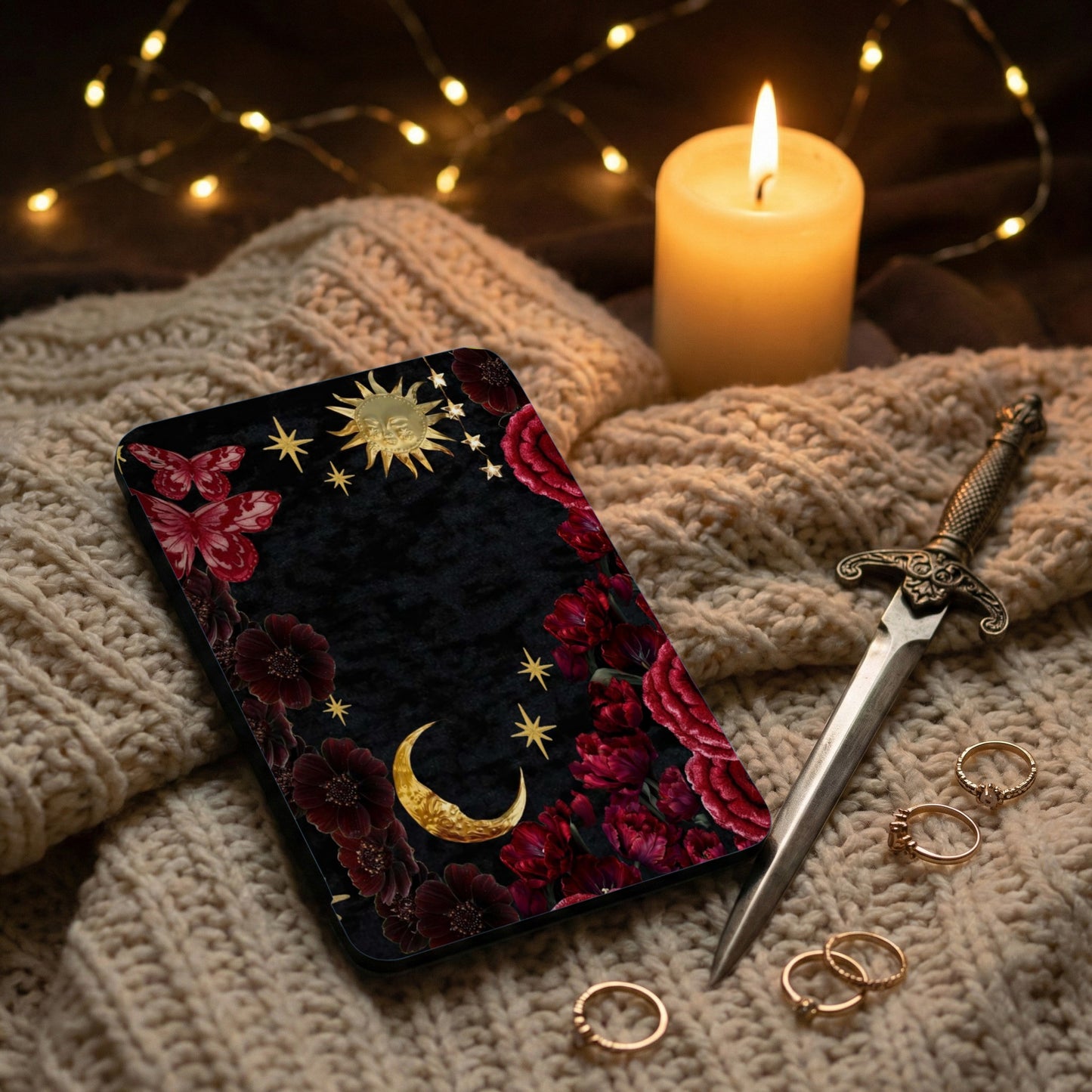 Black phone case with sun, moon, stars, butterflies, and floral design.