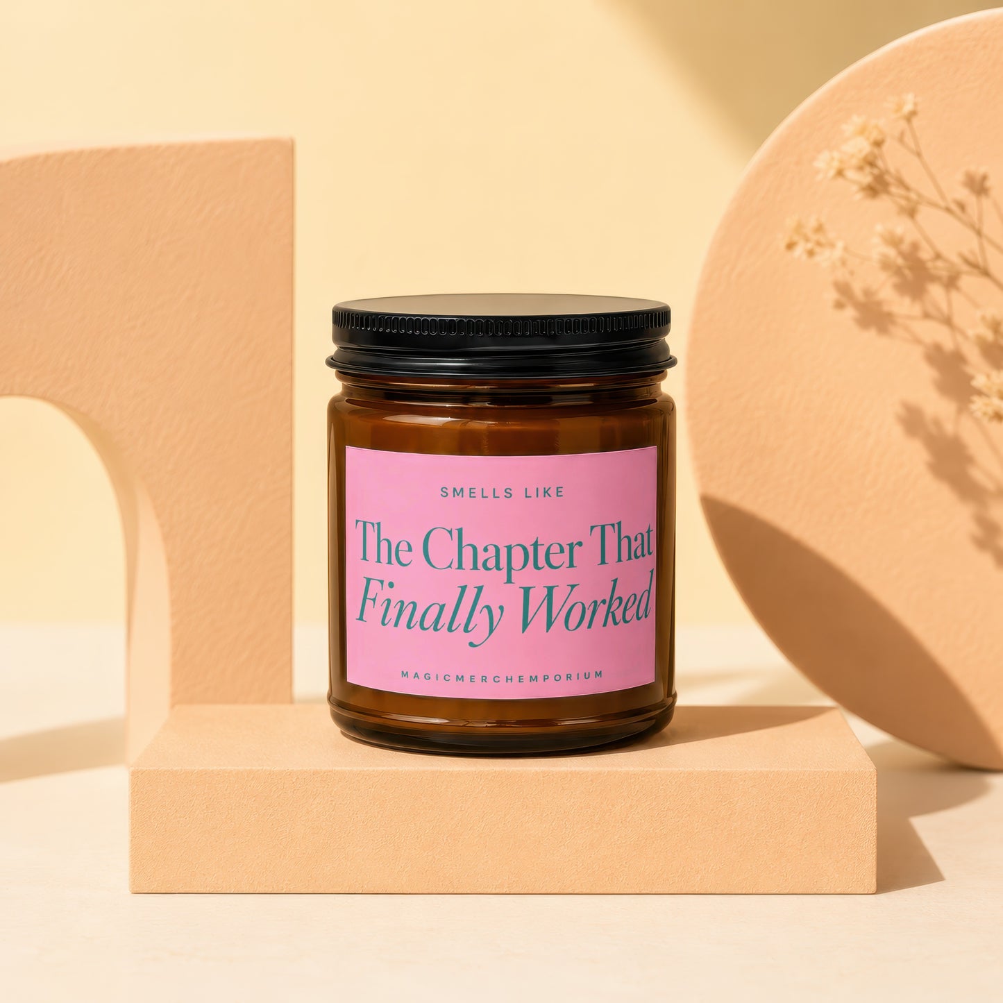 Brown glass candle with pink label that reads "The Chapter That Finally Worked."