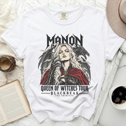 White t-shirt with "MANON QUEEN OF WITCHES TOUR BLACKBEAK THE THIRTEEN" graphic.
