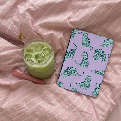 Purple case with teal tiger pattern next to matcha drink and lip balm.