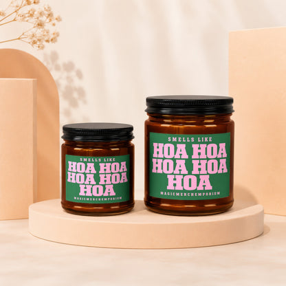 Two amber glass candles with black lids, labeled "Smells Like Hoa Hoa Hoa".