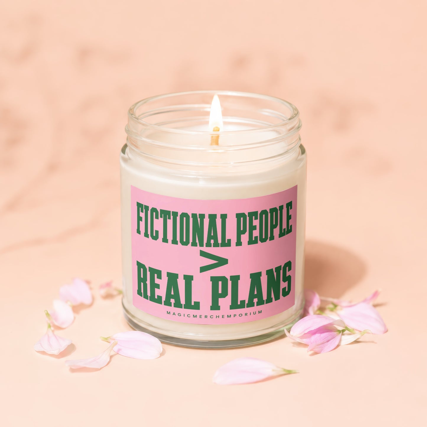 Candle with lit wick and pink label that reads "FICTIONAL PEOPLE > REAL PLANS"