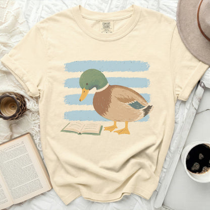 Cream t-shirt with graphic of a duck reading a book on a striped background.