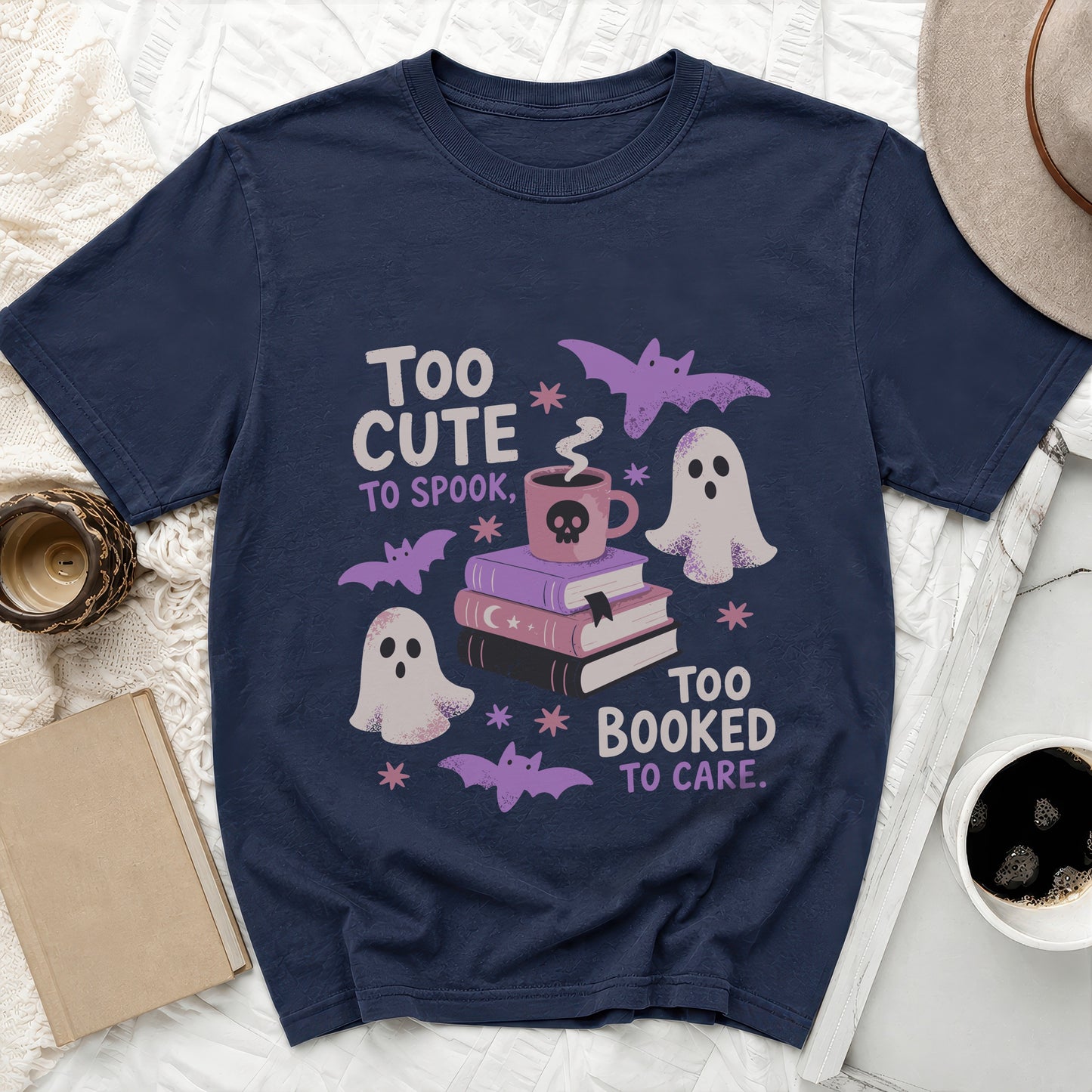 Navy t-shirt with text "Too cute to spook, too booked to care" and Halloween graphics.