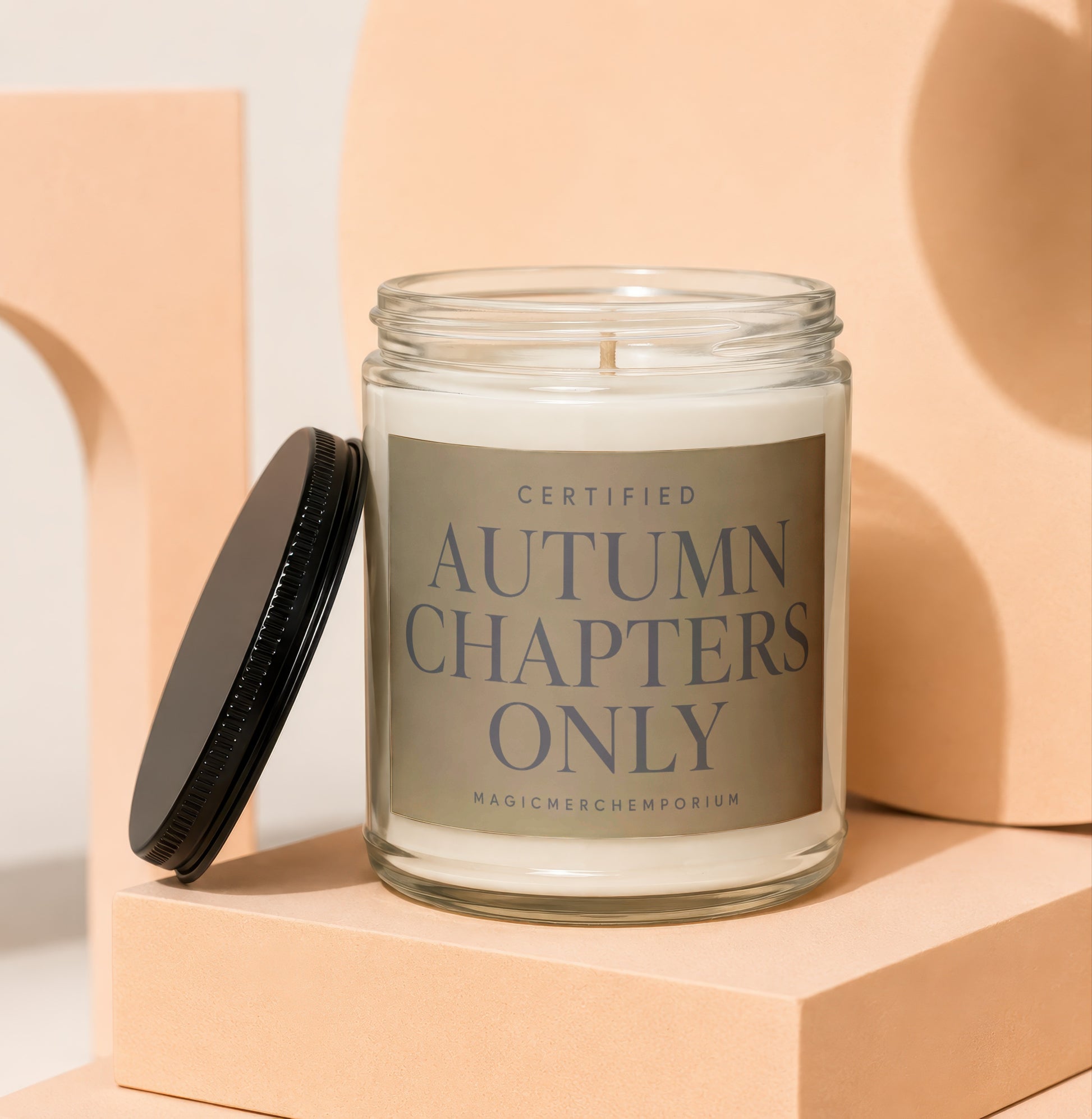 Glass jar candle with black lid, labeled "Certified Autumn Chapters Only".