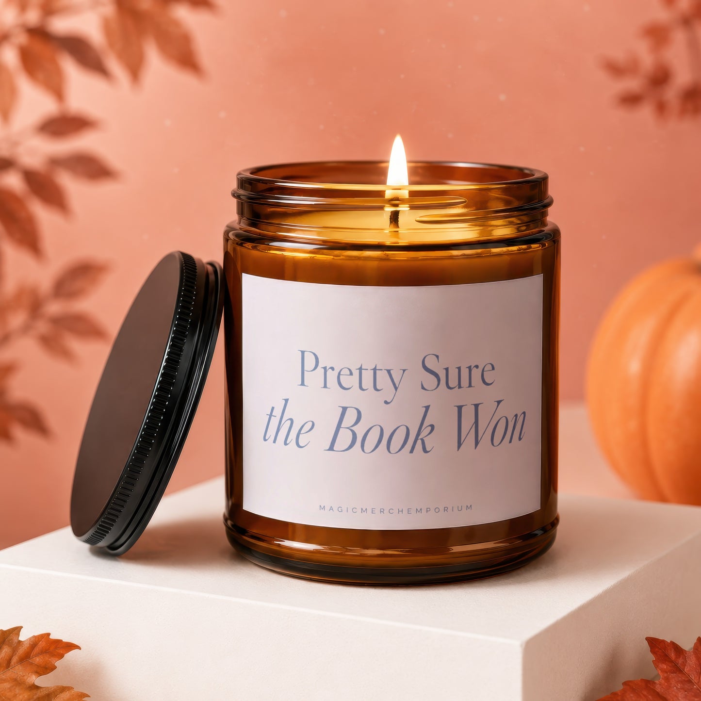 Amber jar candle with lit wick and "Pretty Sure the Book Won" text.
