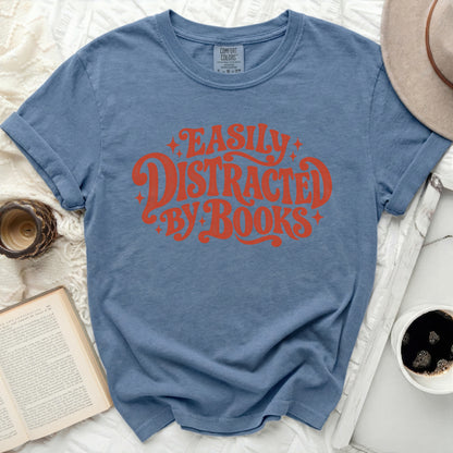 Blue t-shirt with "Easily Distracted By Books" text in orange.