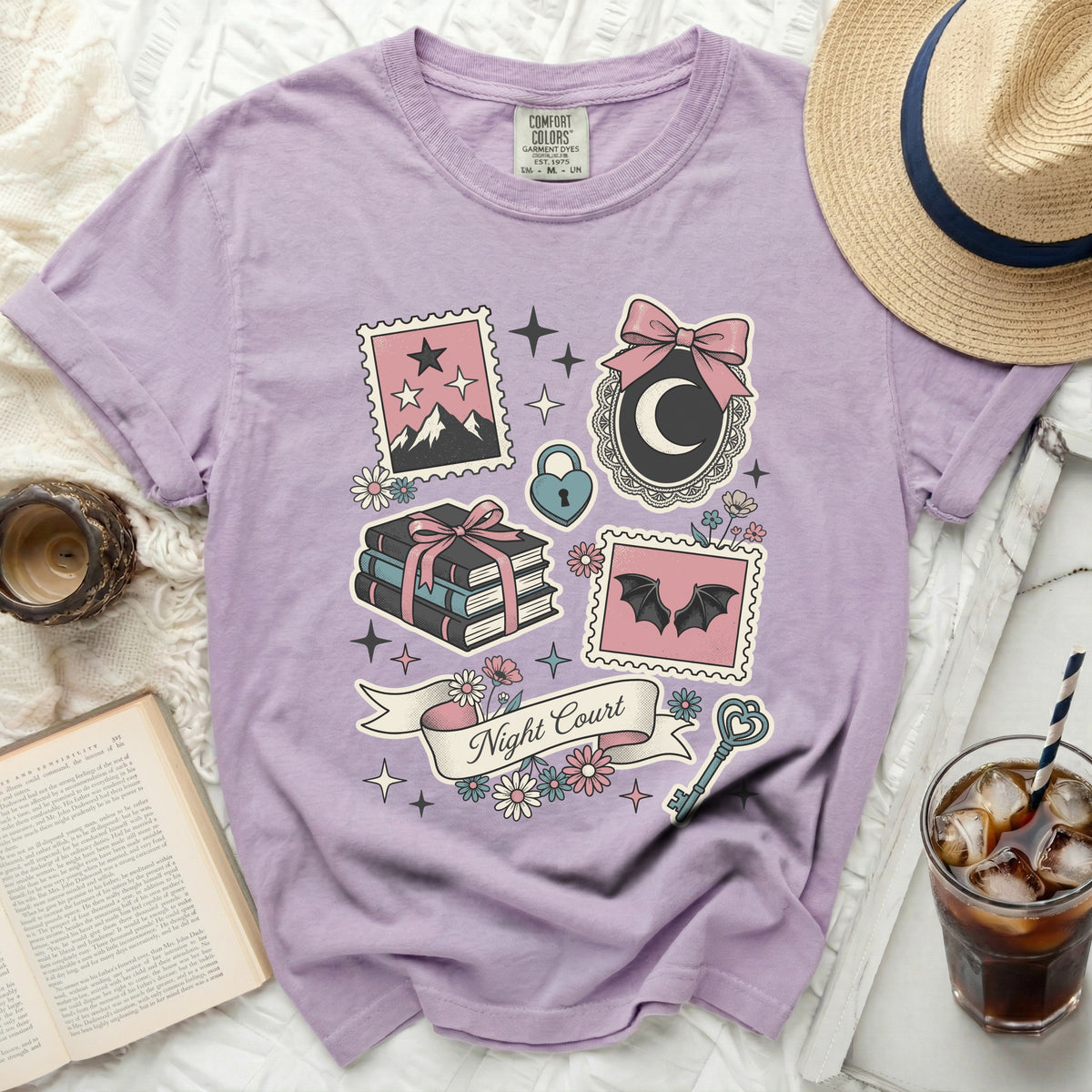 Purple t-shirt with "Night Court" text and whimsical gothic graphics.