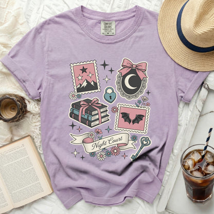 Purple t-shirt with "Night Court" text and whimsical gothic graphics.