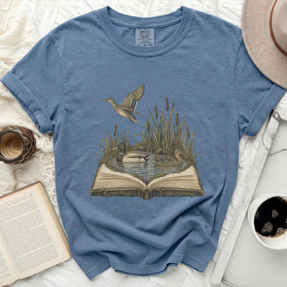 T-shirt with open book, two ducks, and flying duck design.