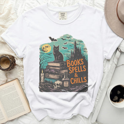White t-shirt with "Books Spells & Chills" Halloween graphic.