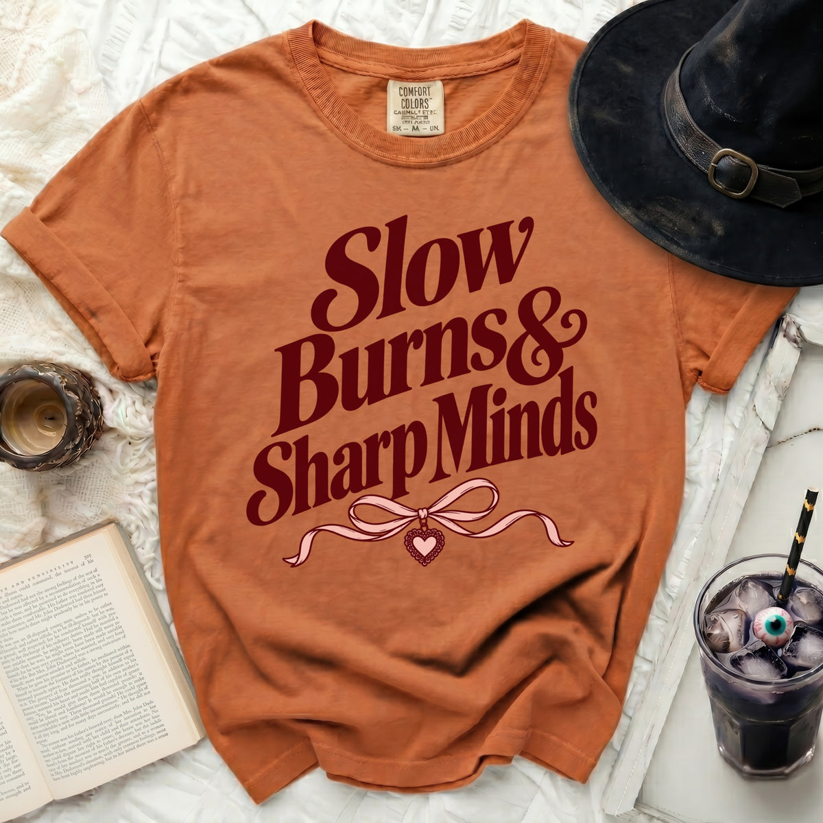 Orange t-shirt with "Slow Burns & Sharp Minds" text and heart design.