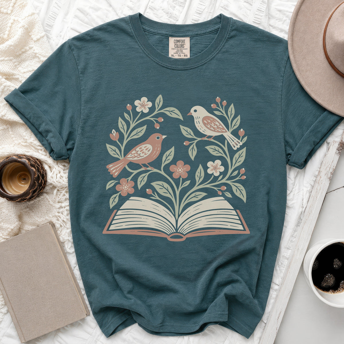 Teal t-shirt with an open book and birds design. Comfort Colors tag visible.