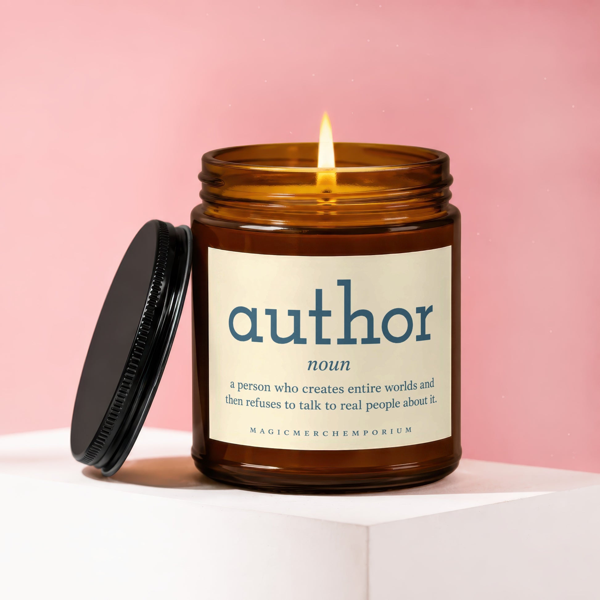 Amber candle with lit flame and label "author noun a person who creates entire worlds...".