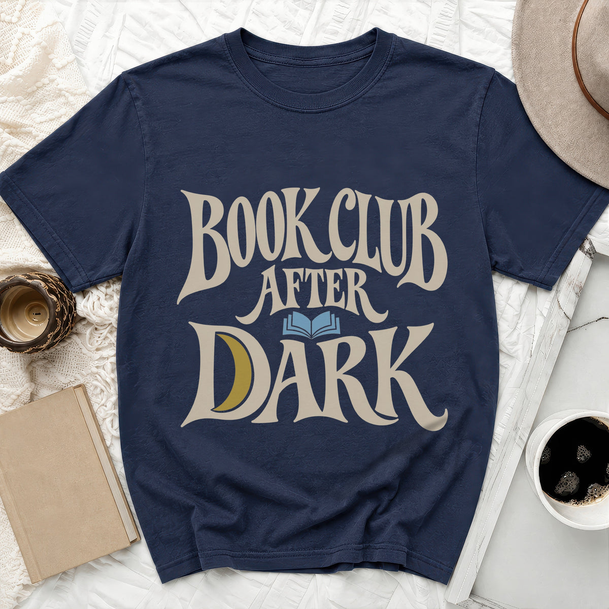 Navy blue t-shirt featuring the beige text BOOK CLUB AFTER DARK with a blue open book and yellow crescent moon.