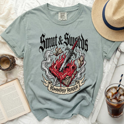 Green t-shirt with "Smut & Swords Romantasy Reader" graphic.