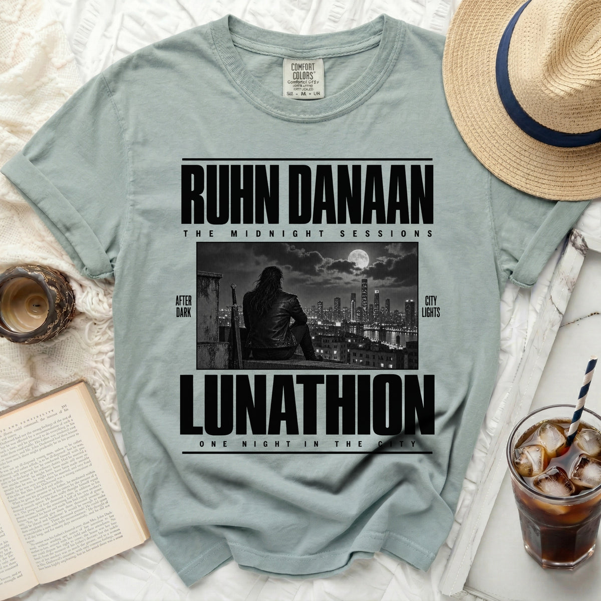 Light blue Comfort Colors t-shirt with "RUHN DANAAN LUNATHION" text and city skyline graphic.