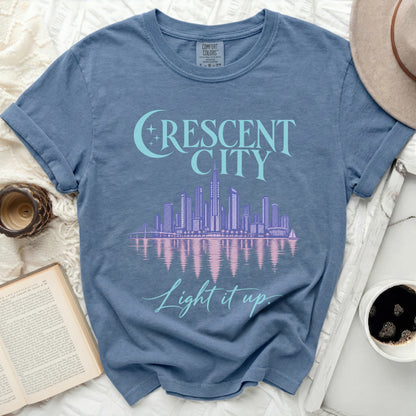 Blue t-shirt with "Crescent City Light it up" graphic and skyline