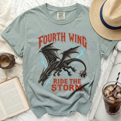 Light blue t-shirt with black dragon graphic and text "FOURTH WING RIDE THE STORM".