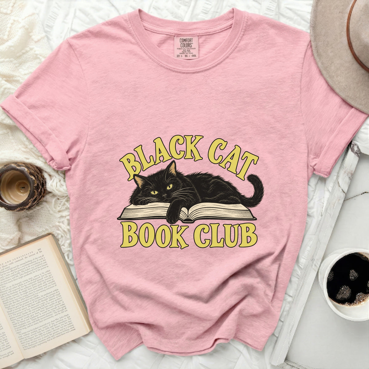 Pink t-shirt with "Black Cat Book Club" graphic featuring a black cat on a book.