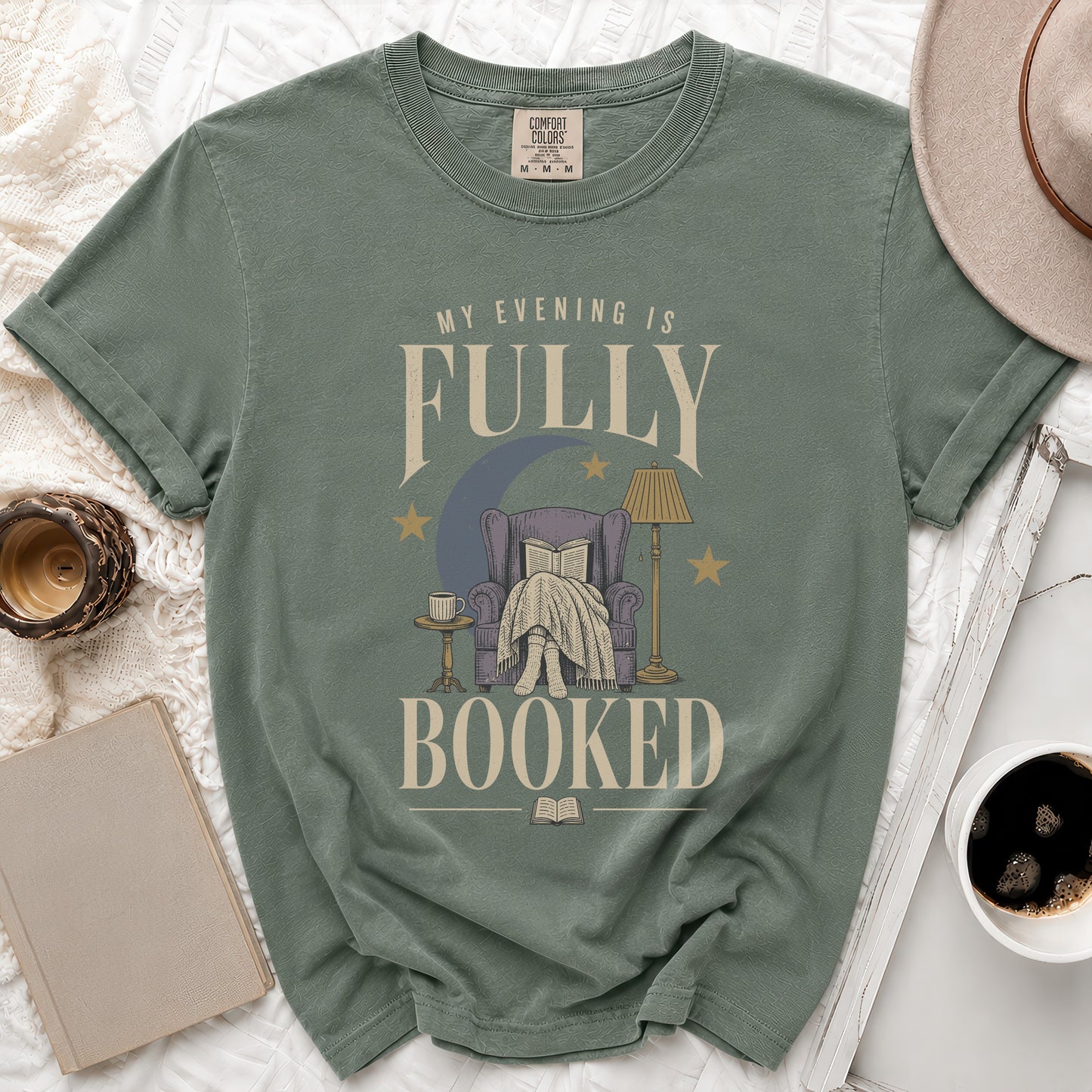 T-shirt with "My evening is fully booked" text and illustration of person reading in armchair.