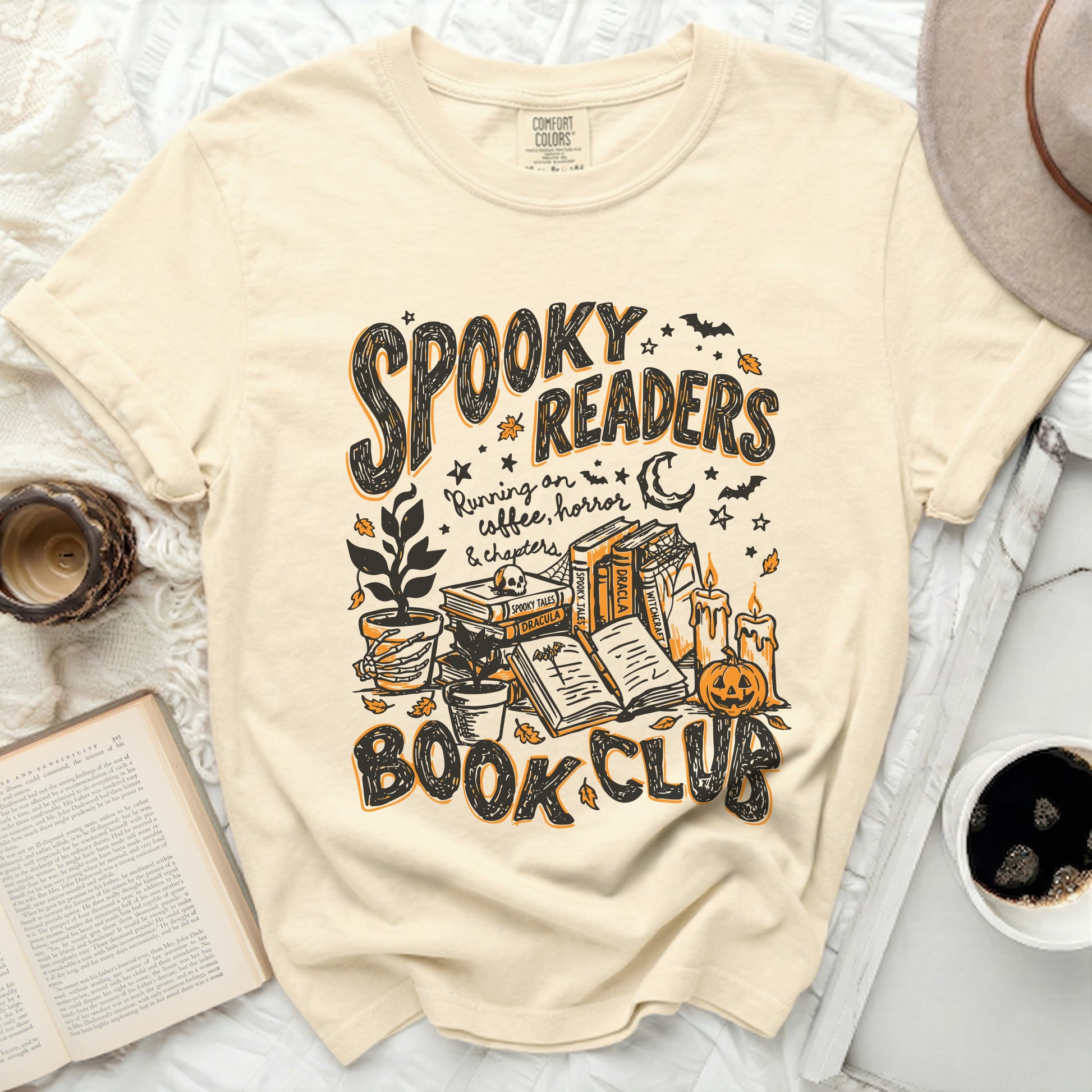 Cream t-shirt with "Spooky Readers Book Club" and Halloween illustrations.