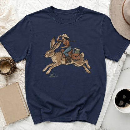 Navy t-shirt with illustration of woman in cowboy hat riding a rabbit carrying books.