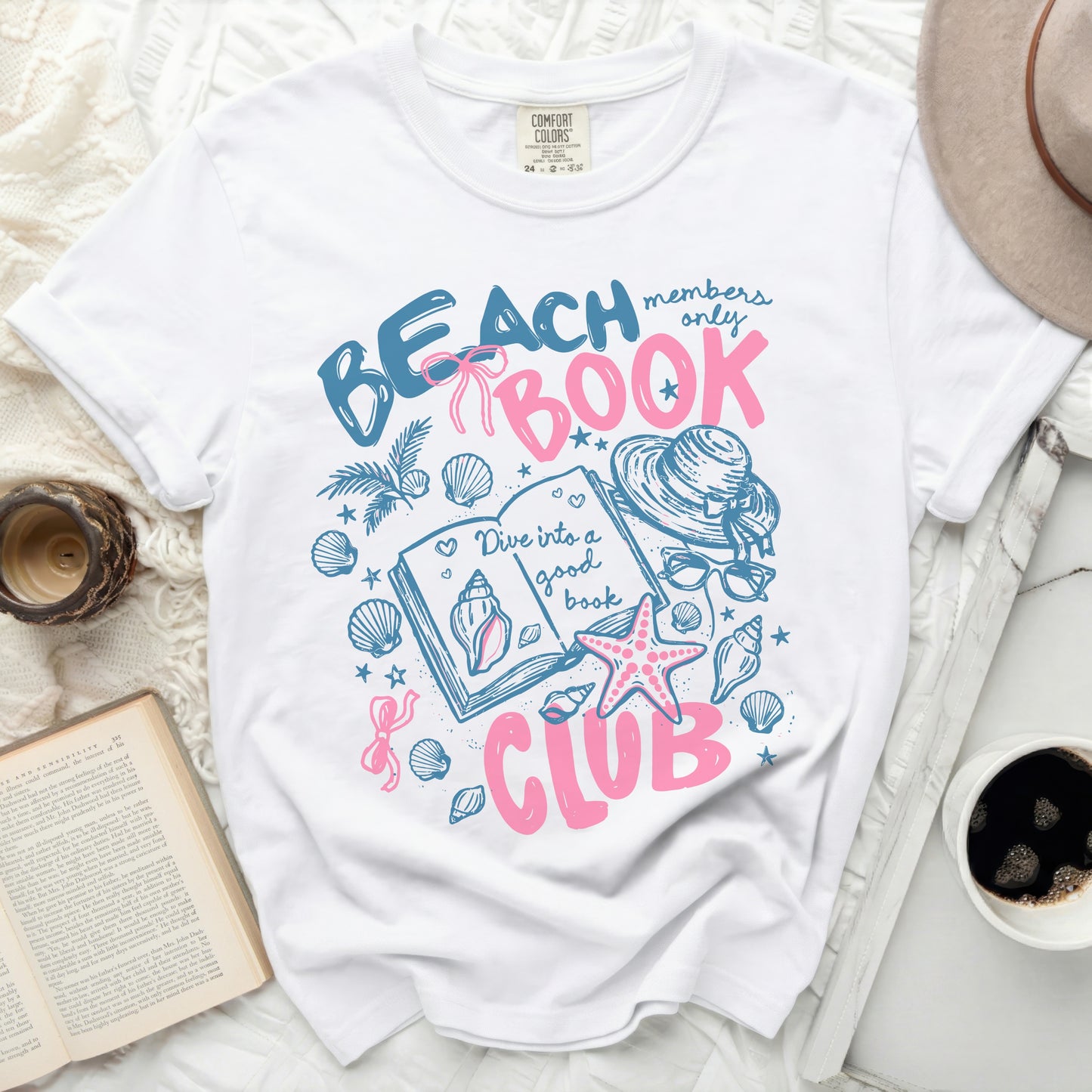 White t-shirt with "Beach Book Club" graphic and seashells.