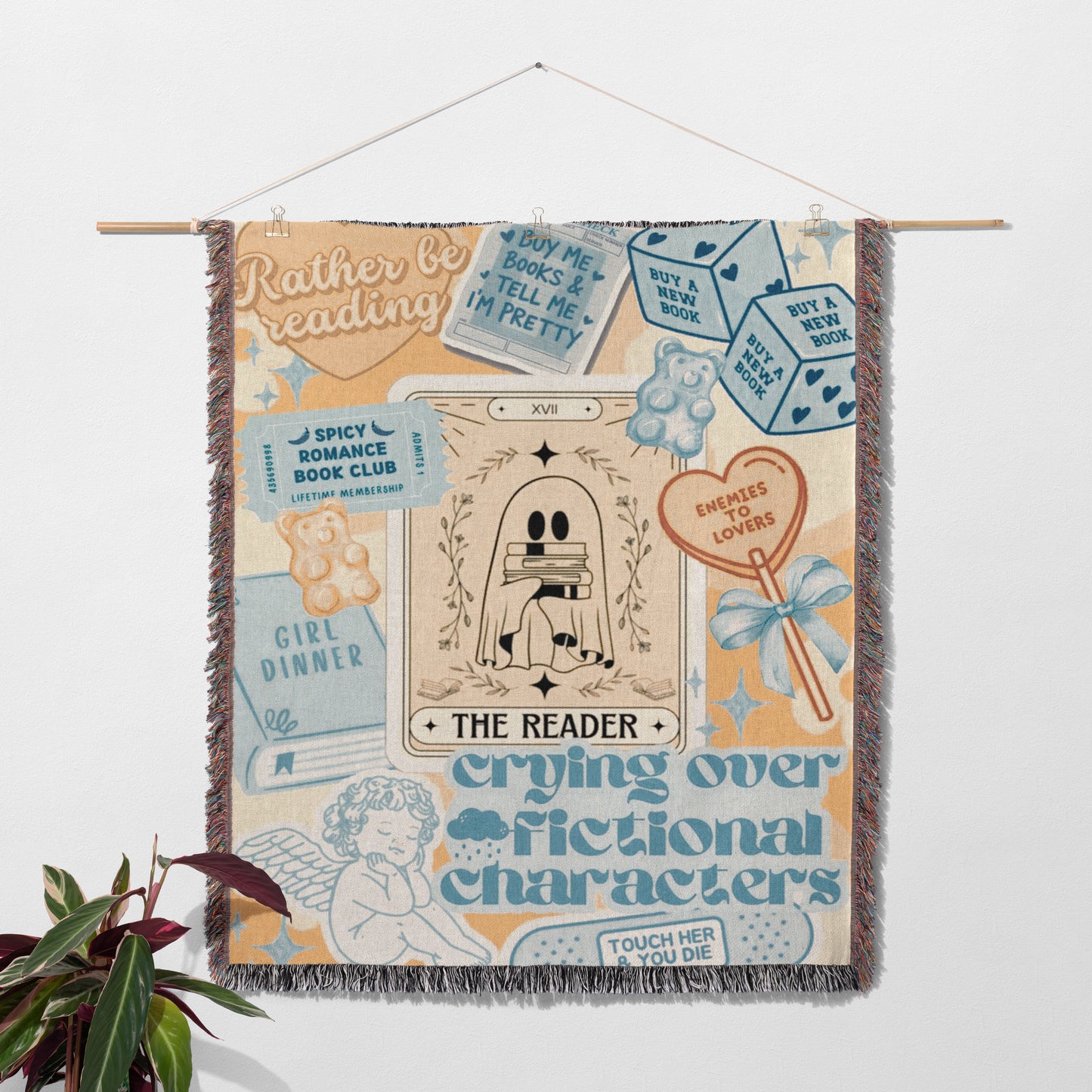 The image is a colorful and whimsical tapestry featuring various elements related to reading and storytelling, including a tarot card, a teddy bear, a book, and a heart.