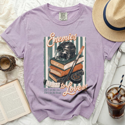 Purple t-shirt with "Enemies to Lovers" text and hockey imagery.