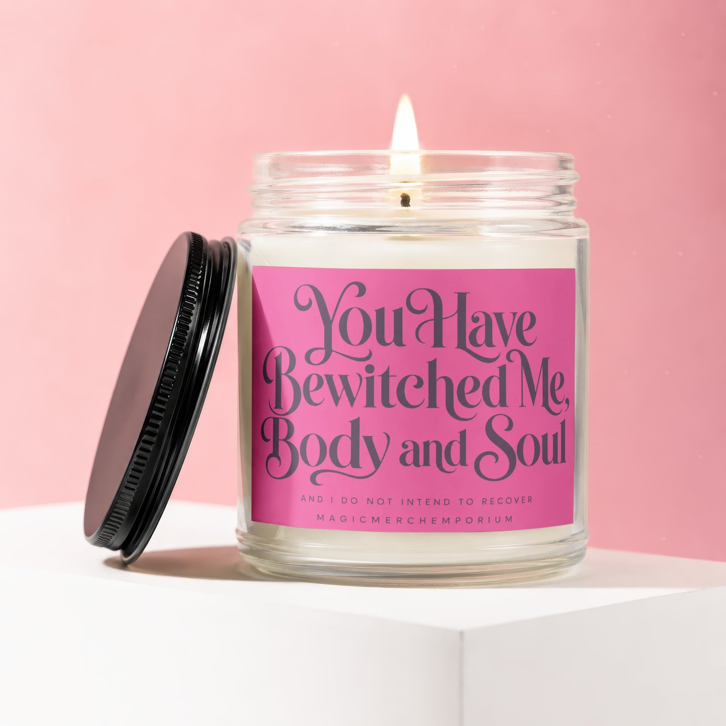 Jar candle on white surface with pink background, text reads "You Have Bewitched Me, Body and Soul".