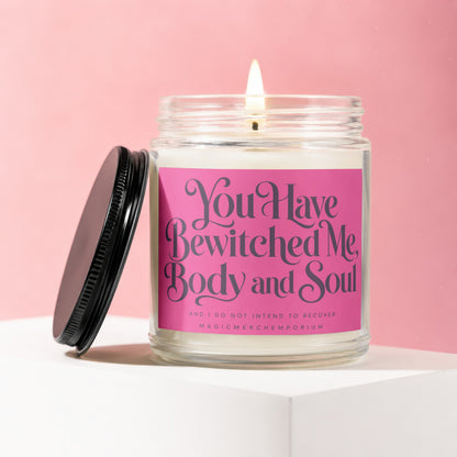Jar candle on white surface with pink background, text reads "You Have Bewitched Me, Body and Soul".