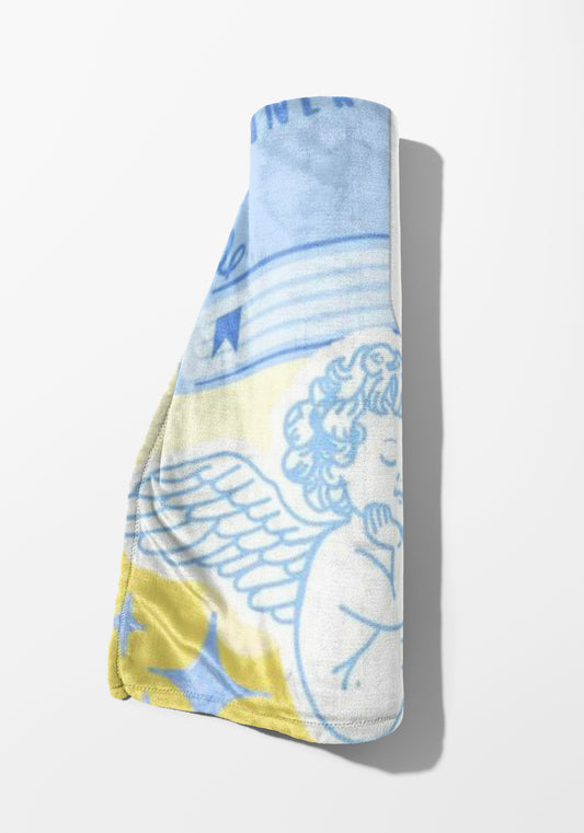 Rolled towel with angel print and yellow and blue watercolor background.